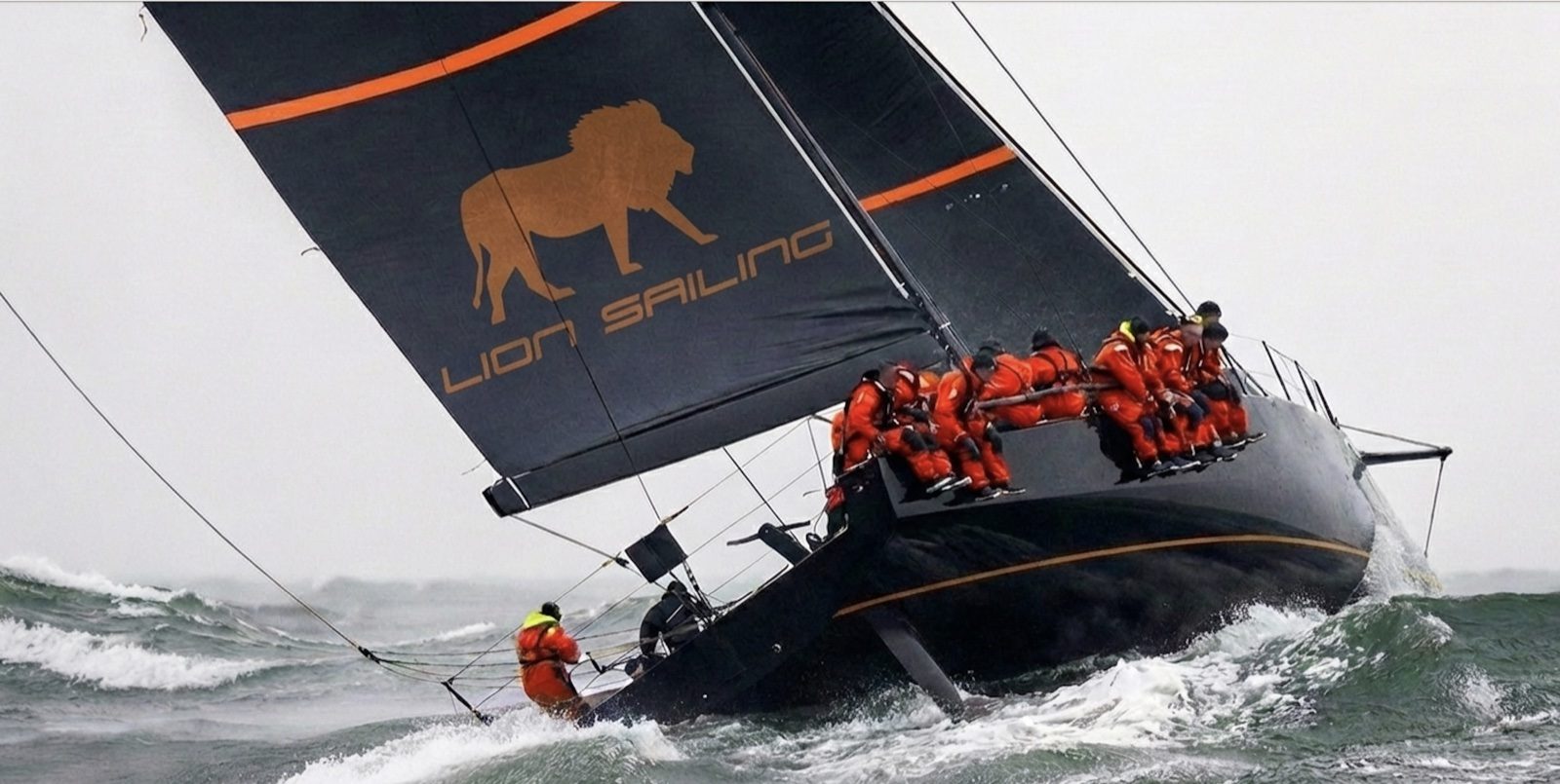 Crew hiking under a Lion Sailing mainsail in heavy air